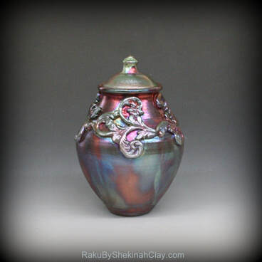 Raku lidded vase in copper and green iridescent colors